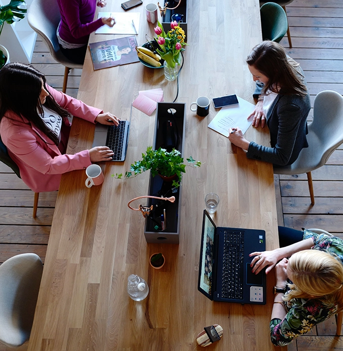 Picture of women working at a long table IT Support advice for UK Charities and Non-profit organisations